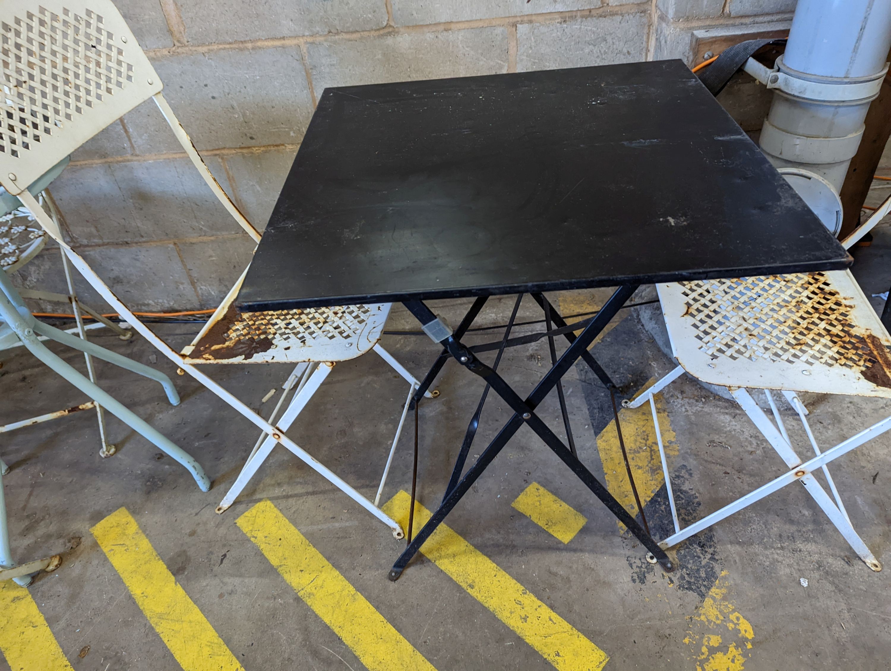 A square metal folding bistro table, width 60cm, height 71cm, together with two metal chairs